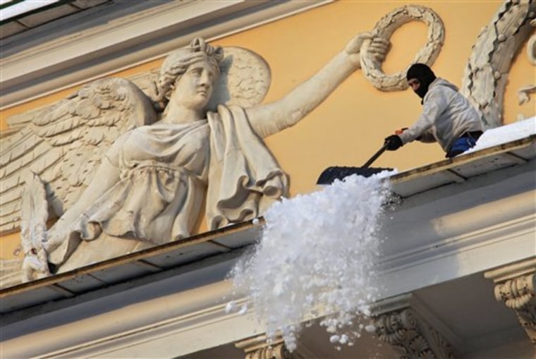 Municipal worker cleans snow from the roof of Aleksandriysky theatre in St. Petersburg, Russia, Tuesday, Nov. 30, 2010. The temperature in St.Petersburg is around -12 C (10 F). (AP Photo/Dmitry Lovetsky)